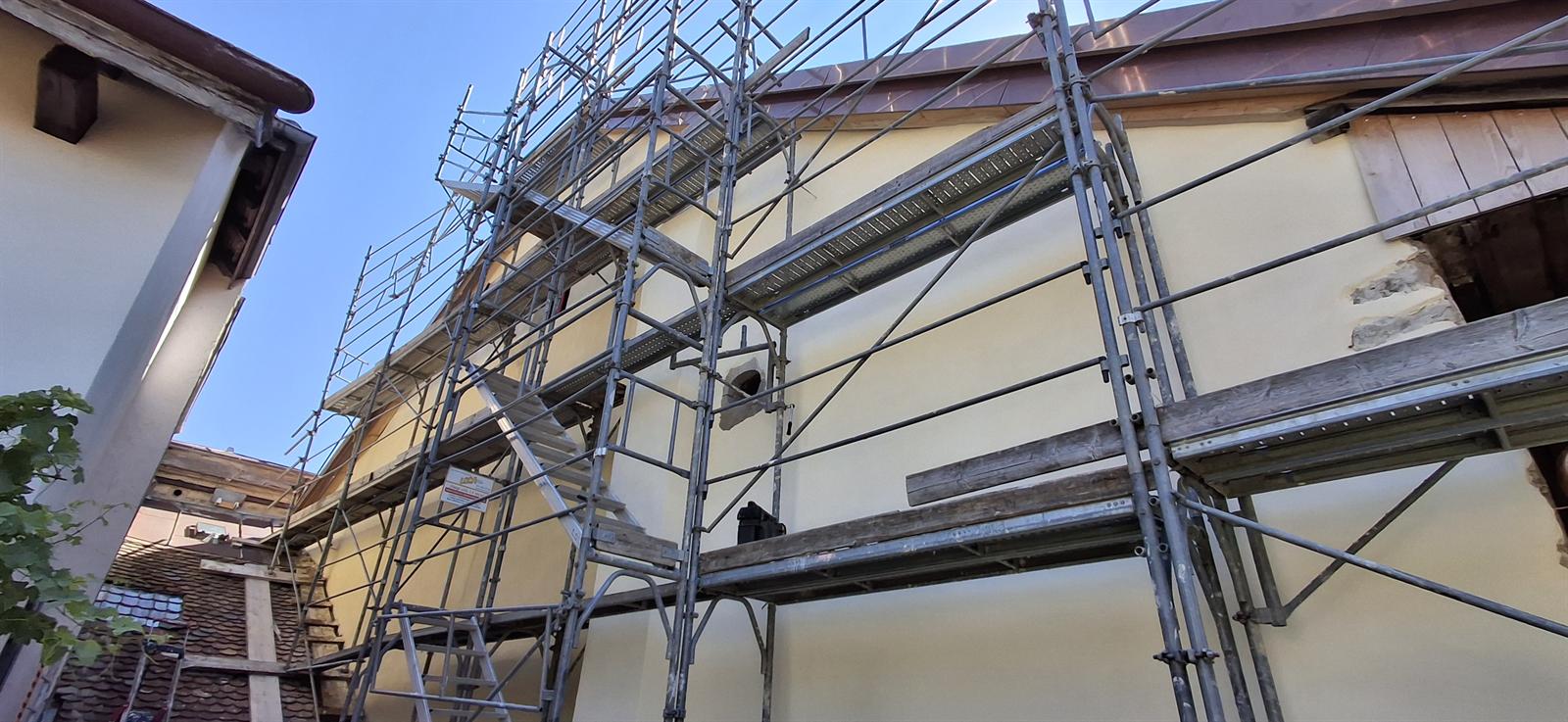 Façade crépie à la chaux avec conduit de cheminée